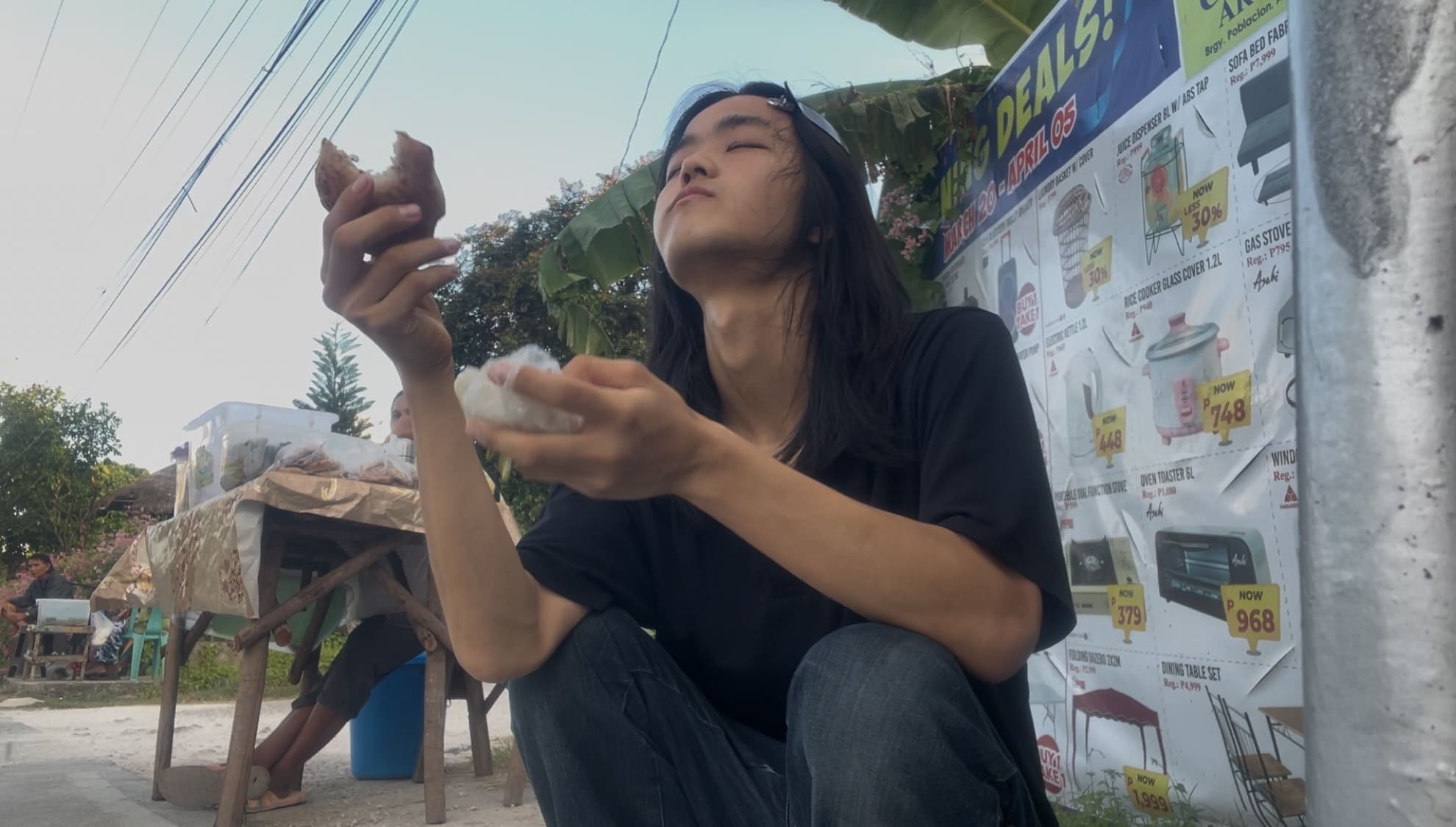a guy eating brown bibingka and thinking.