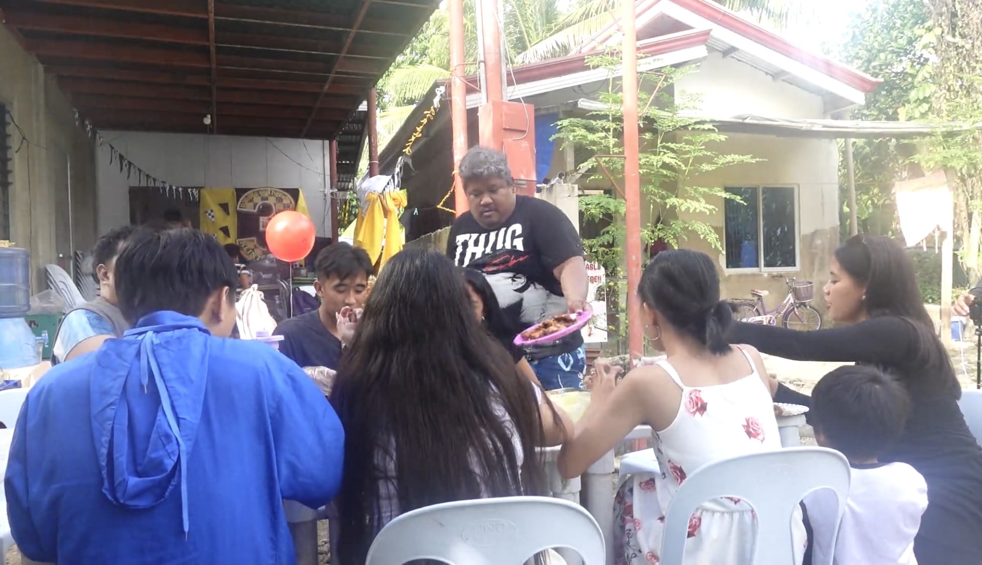 kuya holding a fried lechon and put it on a table.