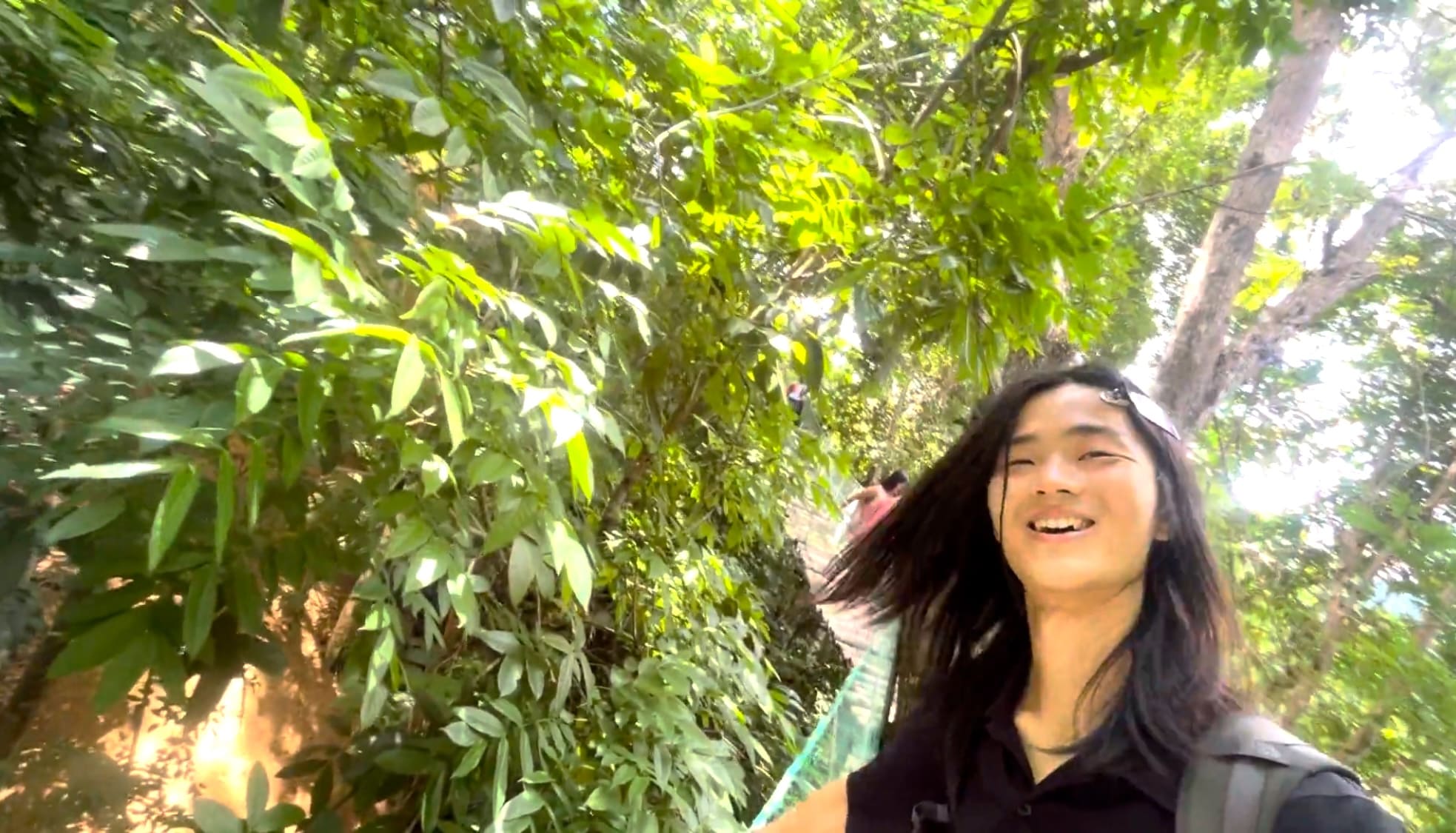 The hanging bridge on the trail to the waterfall in Coal Mountain Resort, Argao and a guy smiling on the bridge