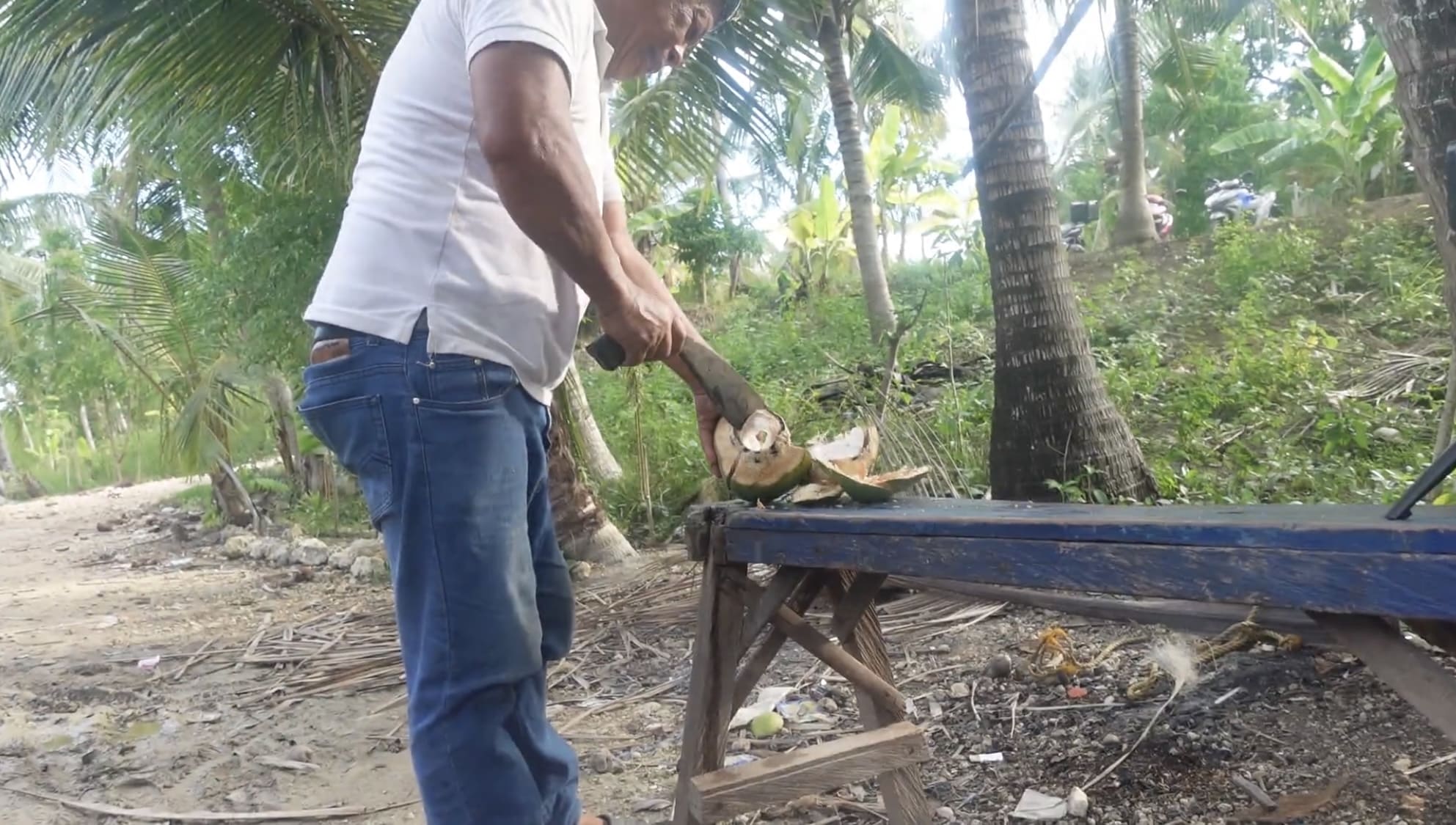 a guy cutting a coconut