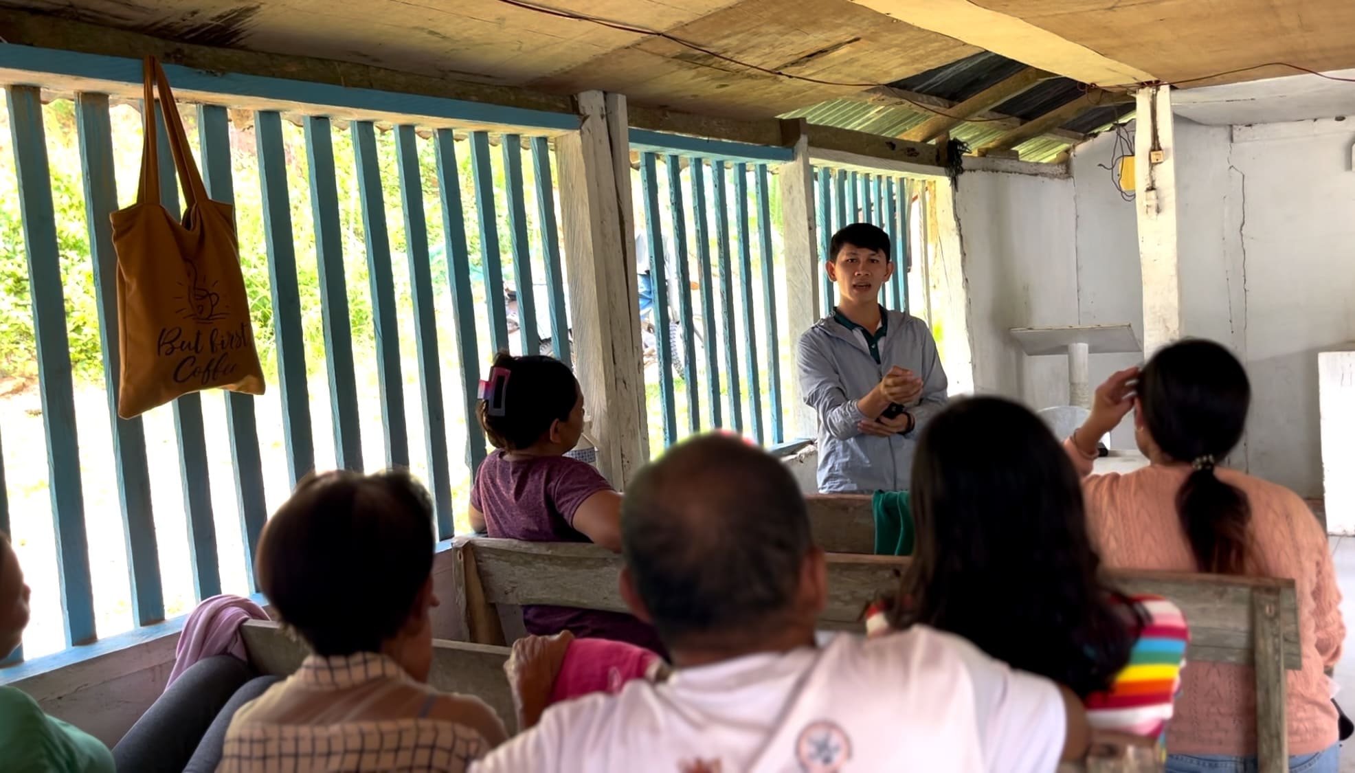 Melvin speaking with farmers during a meeting inside a chapel