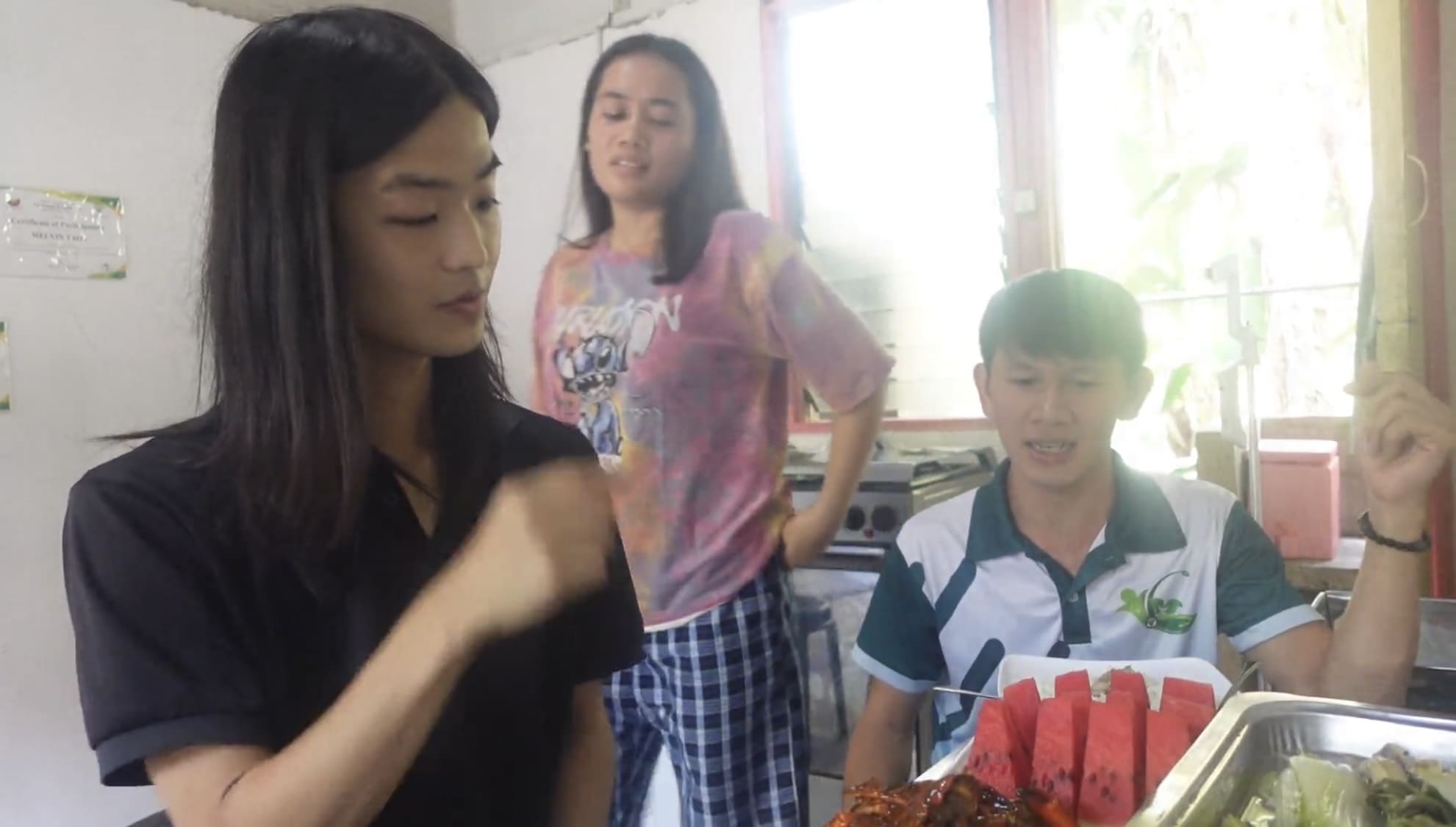 Two men talking with a woman inside a food processing facility