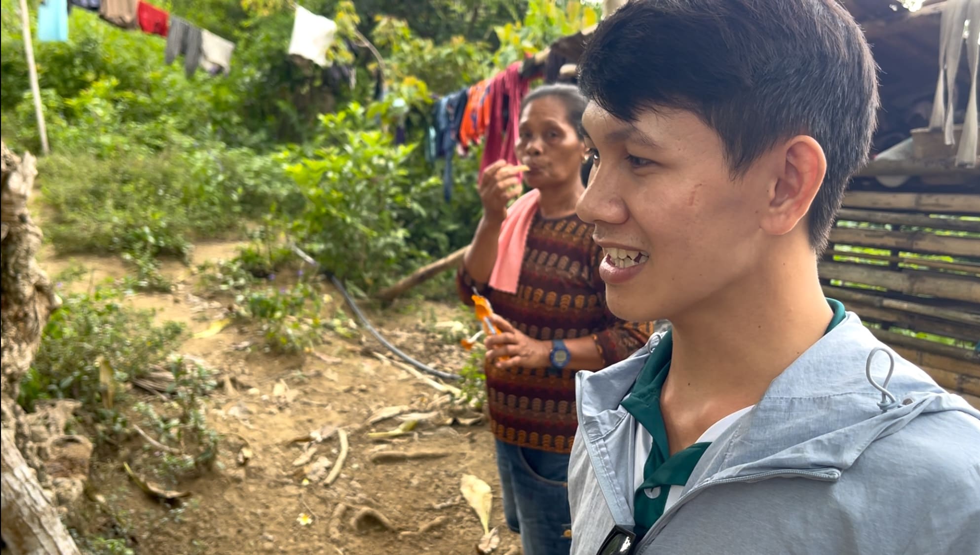 Melvin and a woman near a cassava farm