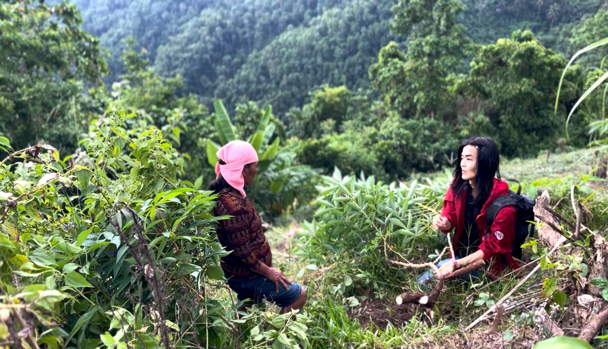 woman and a boy talking in a cassava farm