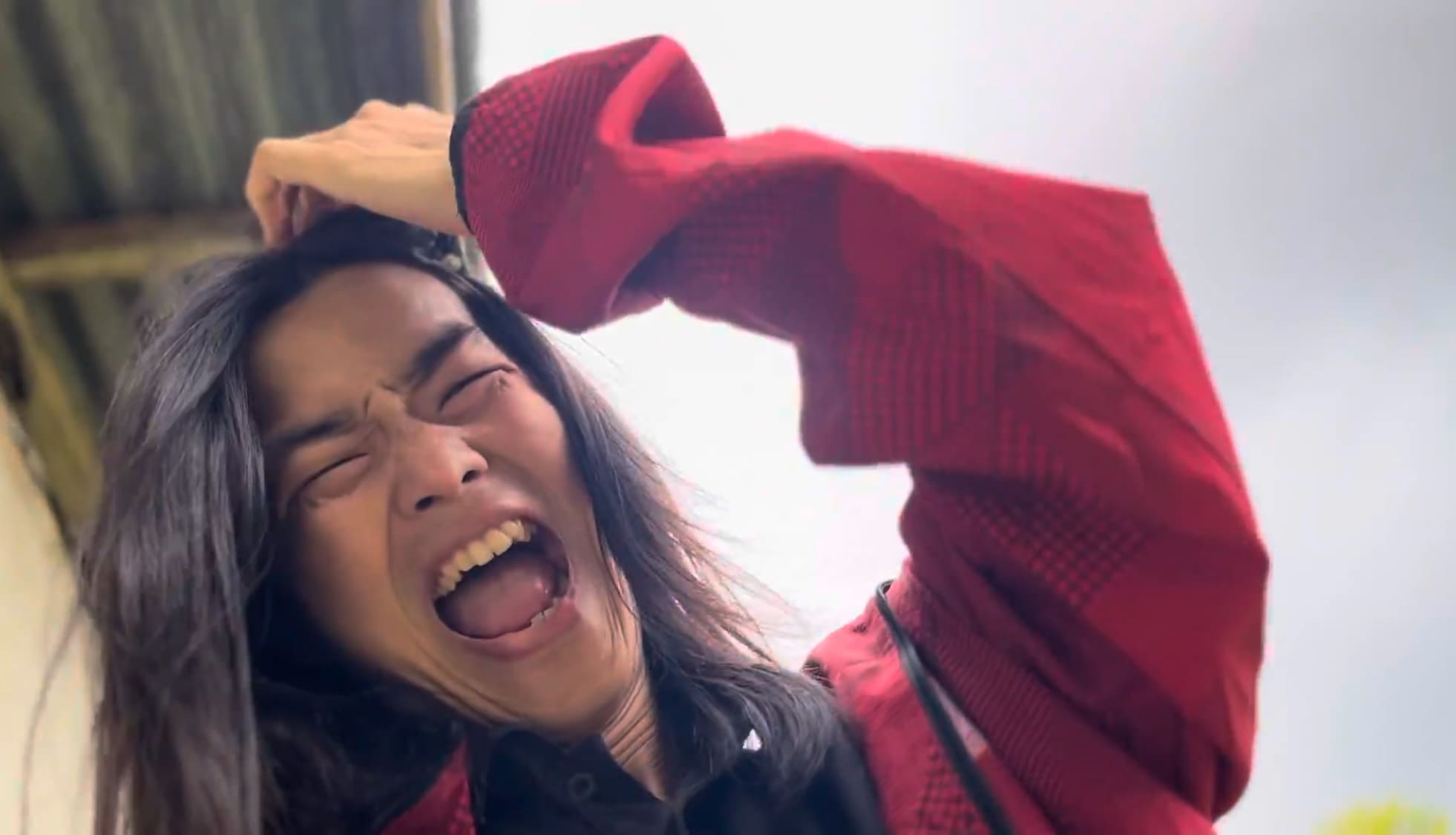 Man making a painful expression after hitting his head on a wall