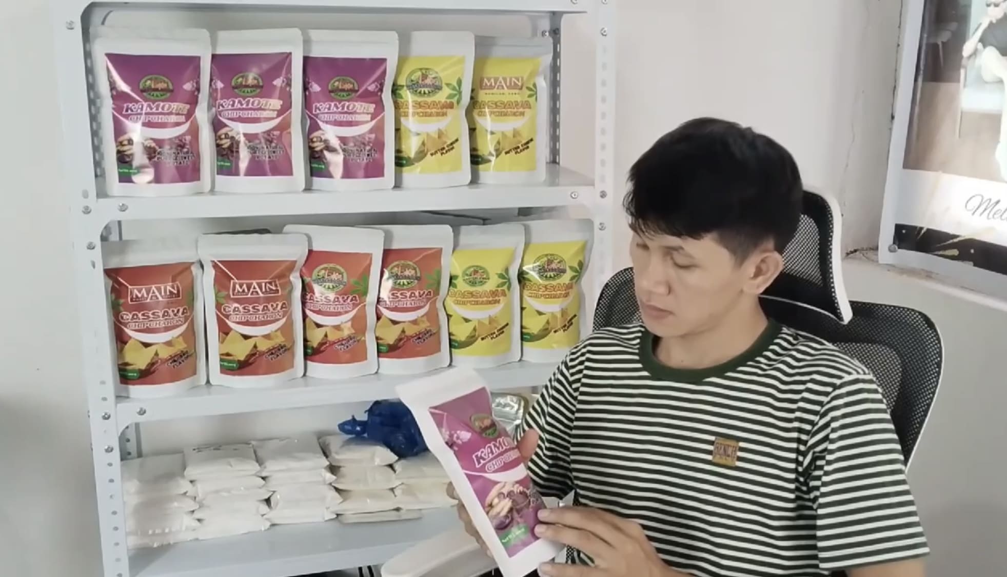 Man holding a bag of kamote chips and looking at it thoughtfully