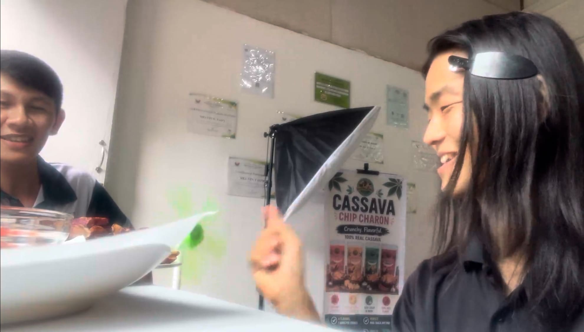 Two men smiling while tasting kamote chips together