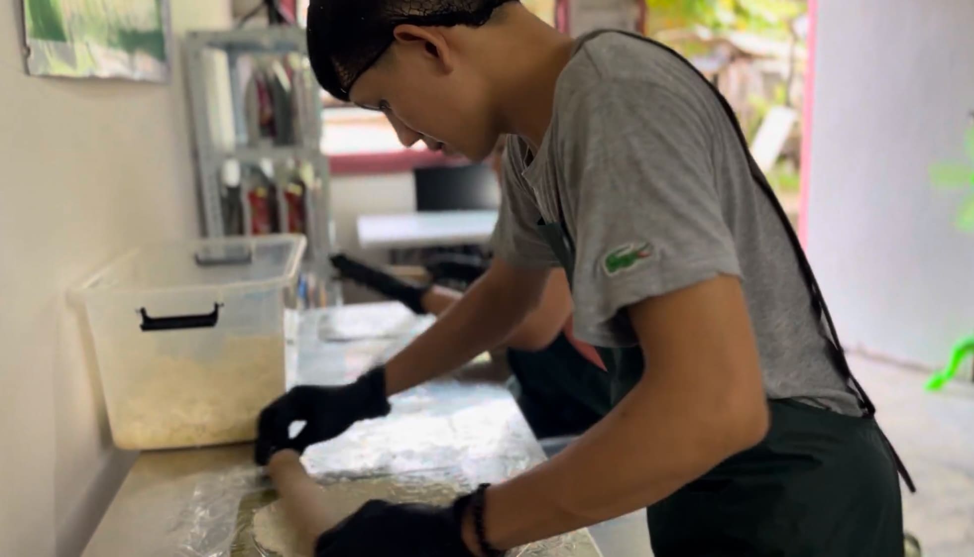 Man spreading thin cassava slices at a food processing facility