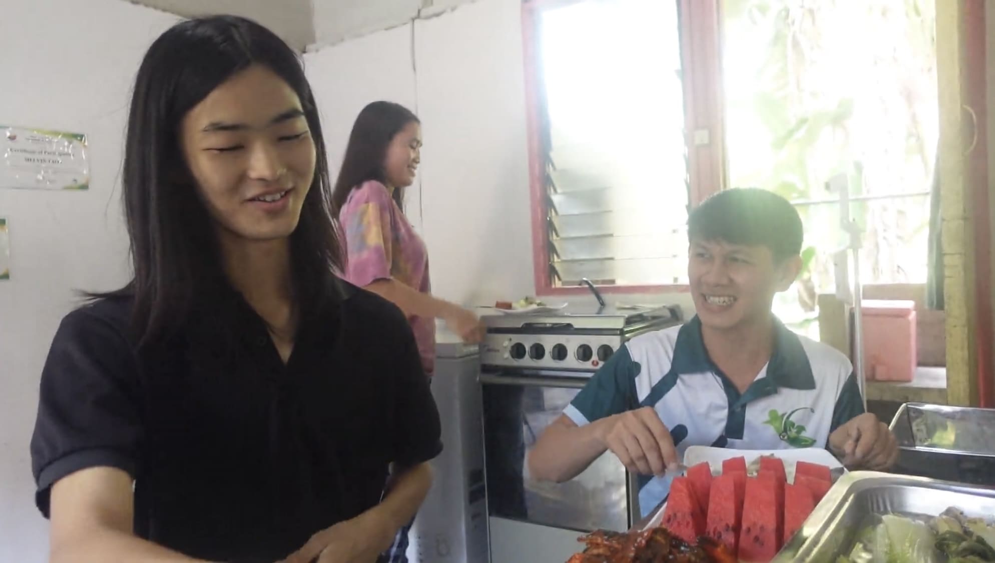 Two men and a woman laughing together over breakfast