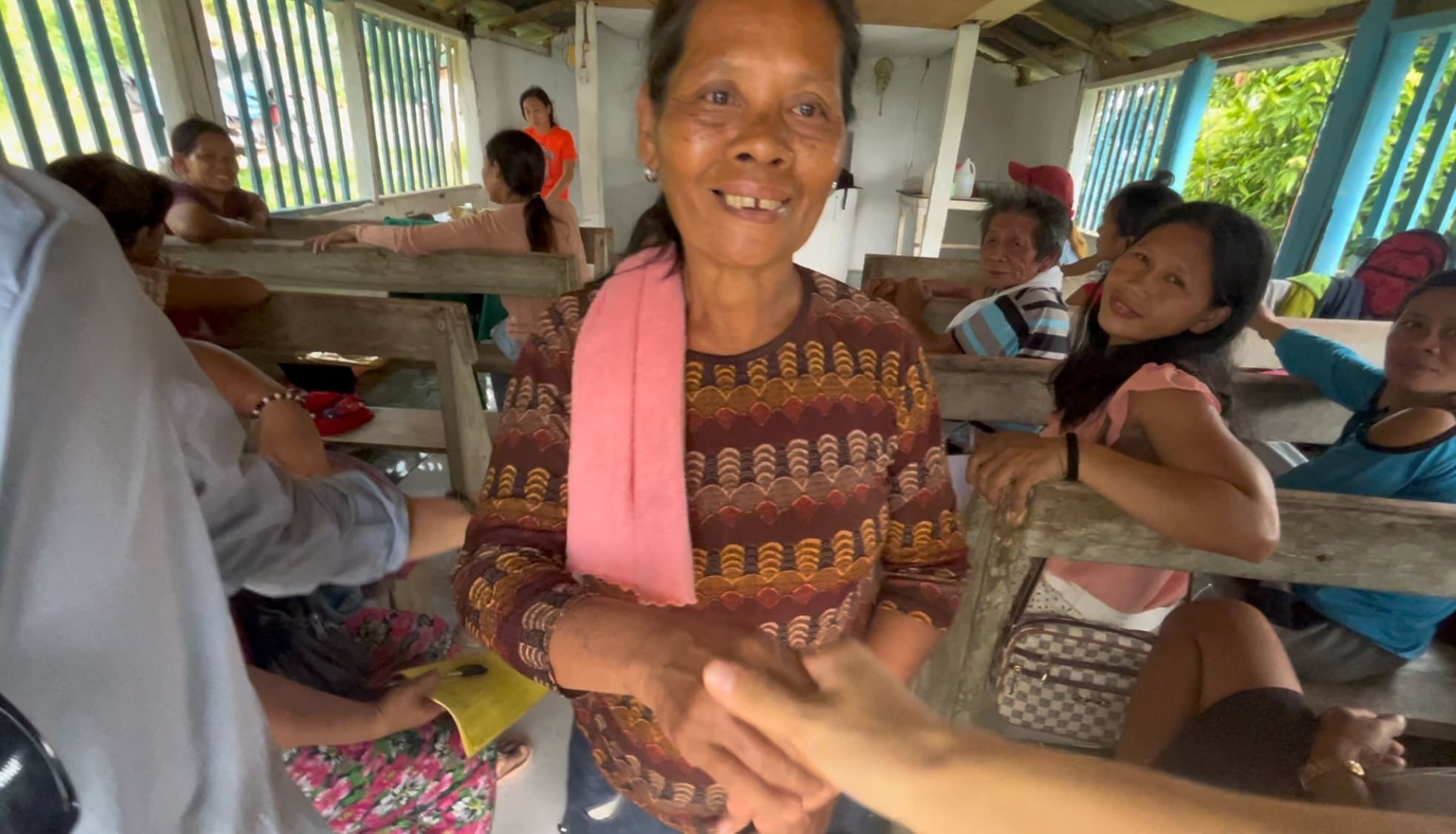 Elderly woman shaking hands with a man