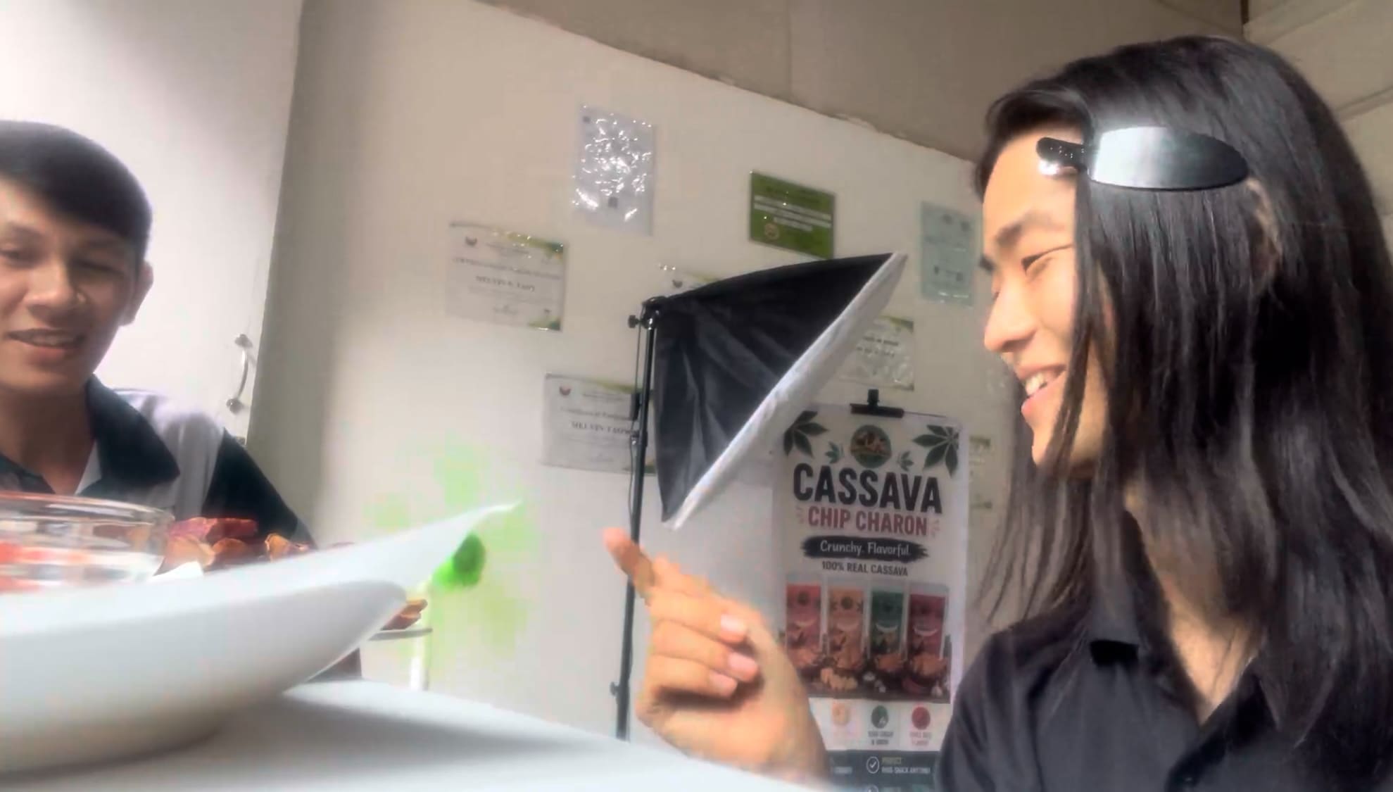 Two men laughing together inside a cassava processing facility in Catmon, Cebu
