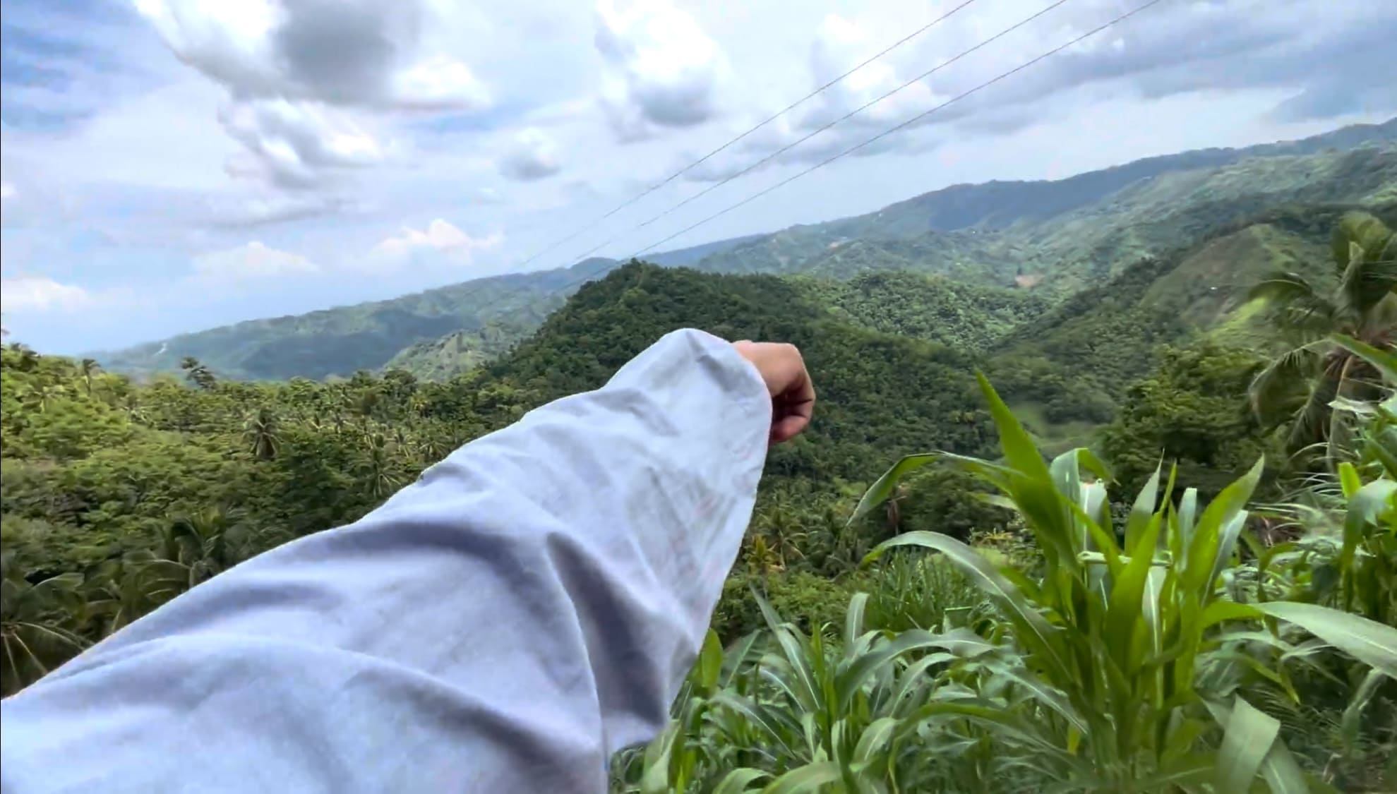 Man pointing at a corn field in the mountains of Cebu