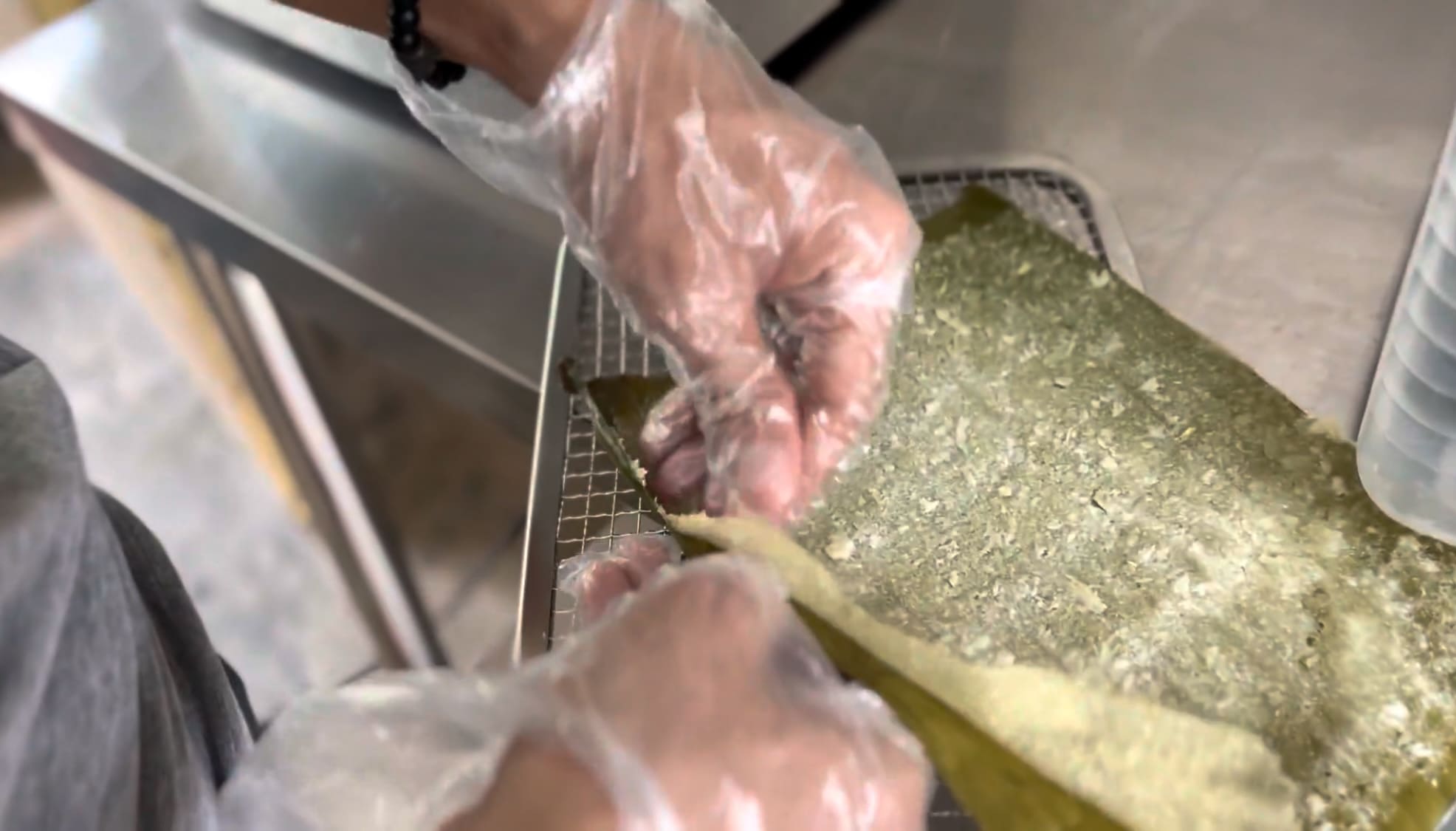 Man's hands preparing cassava during the dehydration process at a small processing facility