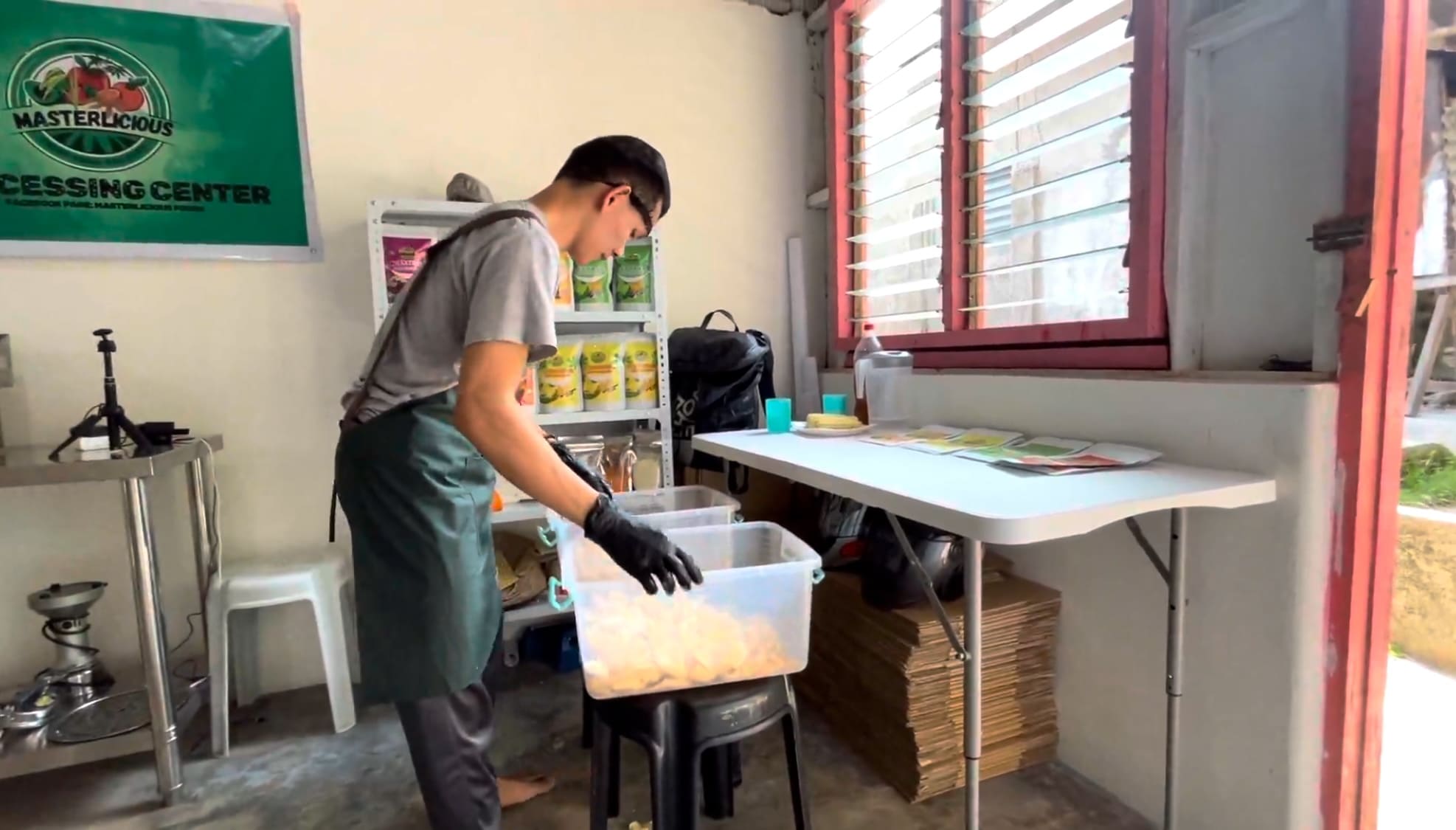 Man seasoning cassava chips in a small food processing facility