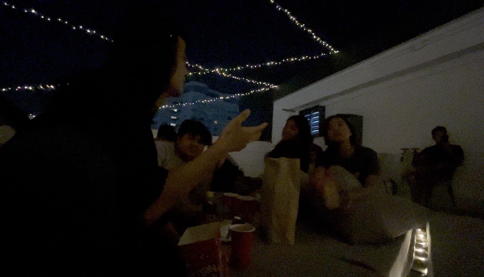 Two men and two women talking together during a Cinema Night on a rooftop deck
