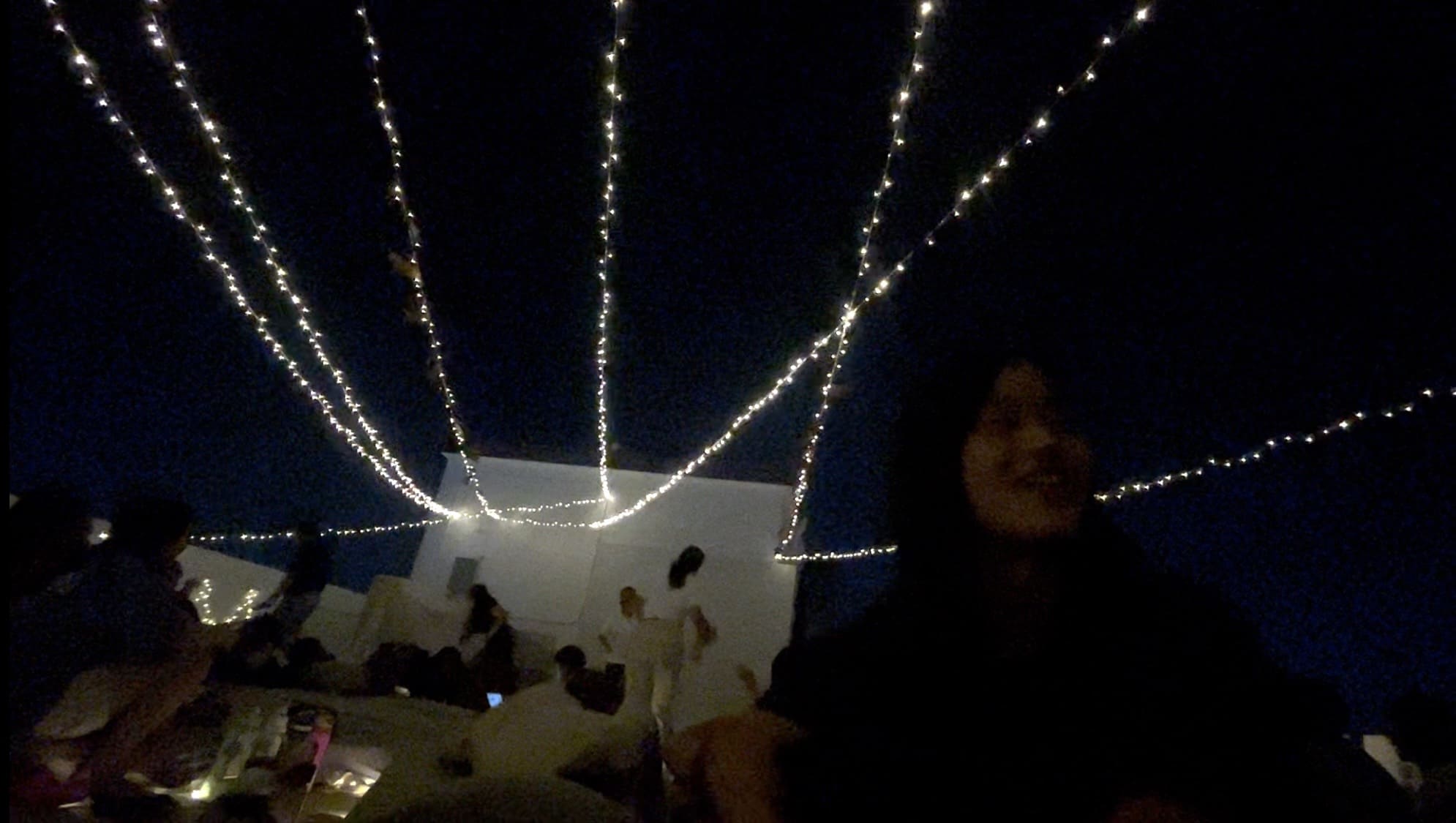 Man smiling during a Cinema Night on a rooftop deck in Cebu