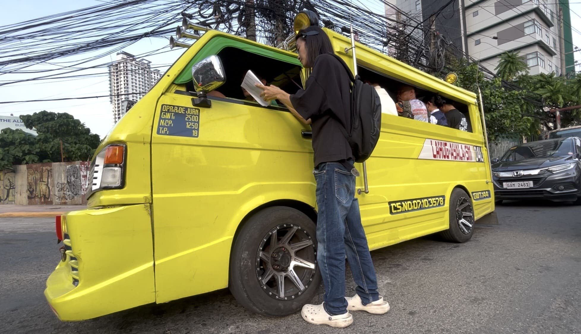 A man interviewing a jeepney driver