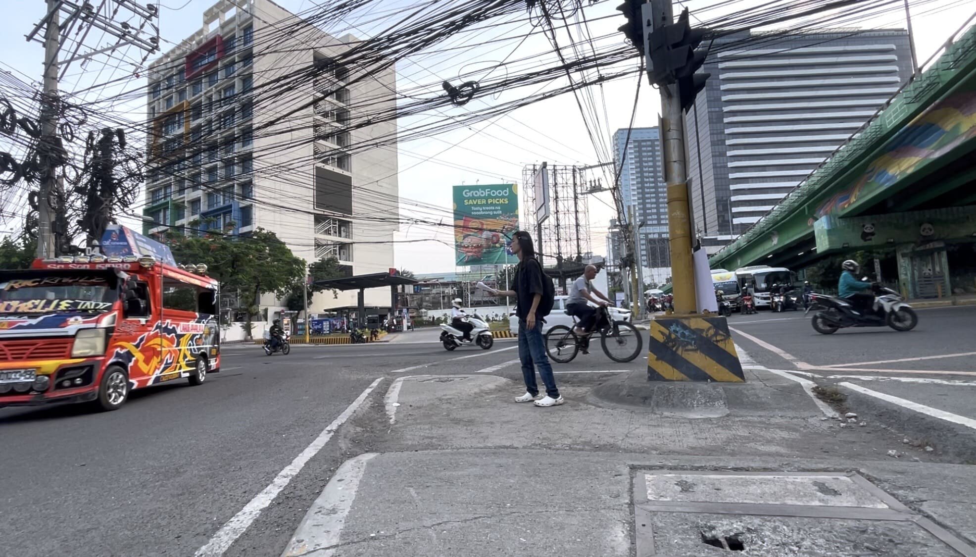 A man standing alone looking at a jeepney