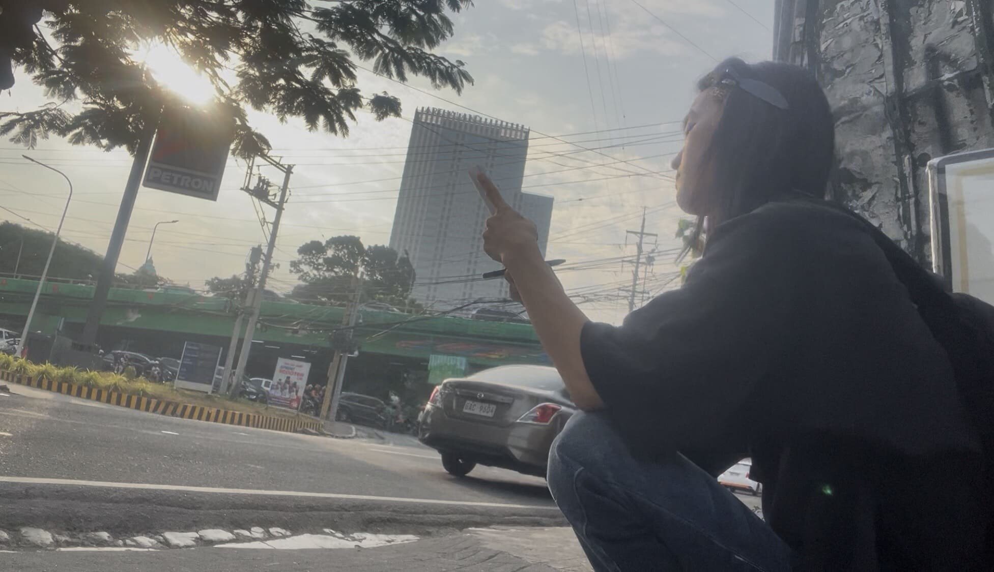 A man crouching on a street