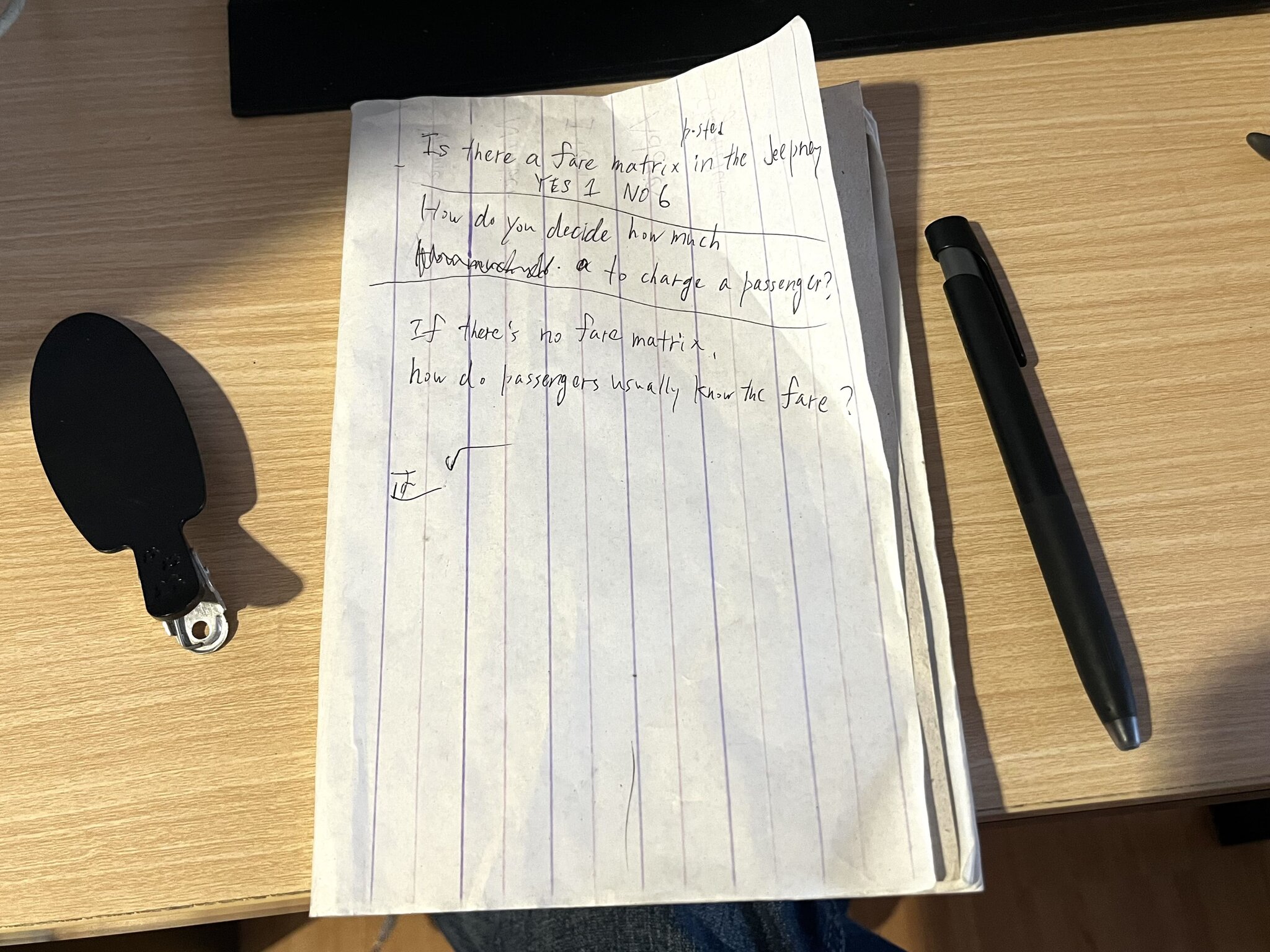 A notebook, pen, and hairpin placed on a desk