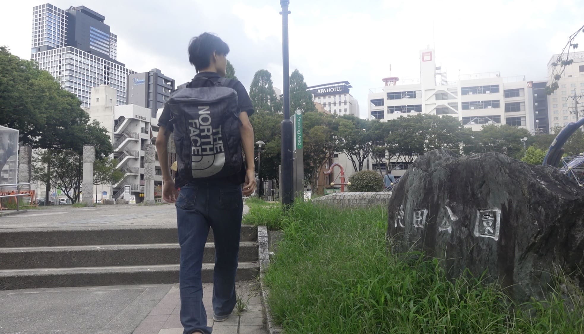 A man walking through Ikeda Park, looking around with a puzzled expression