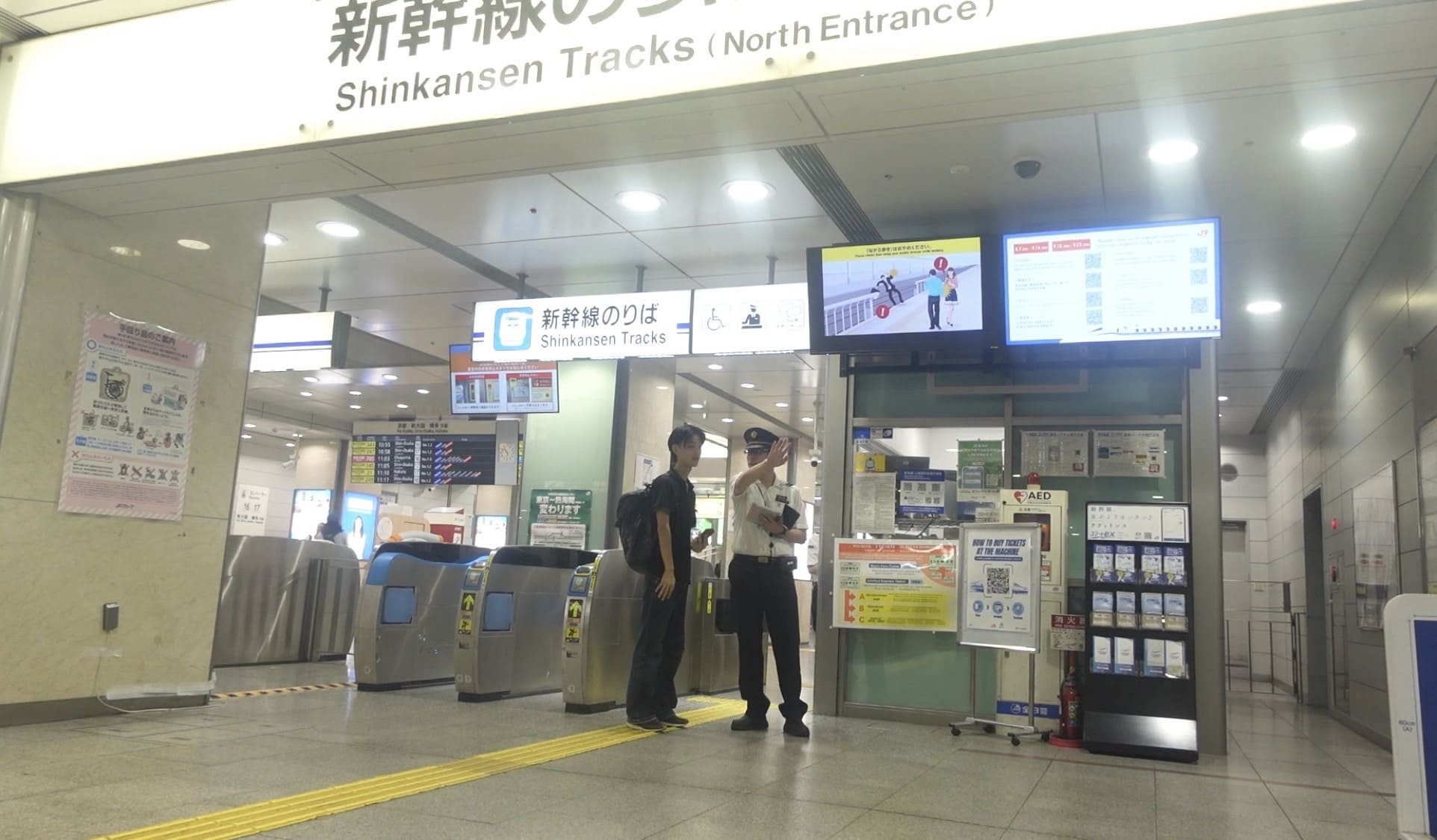 A man asking a train station staff member for directions in Nagoya