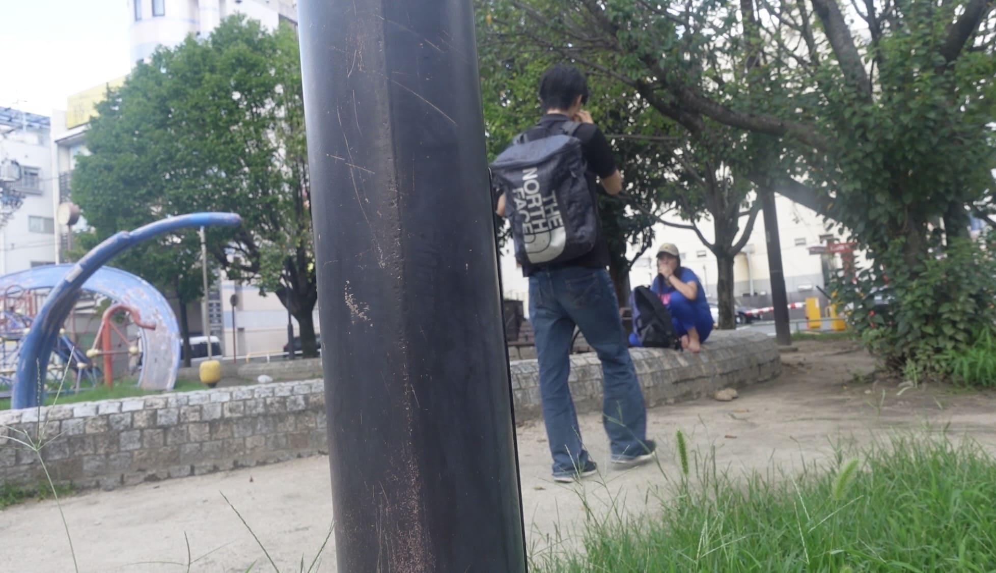 A man walking toward two women in a park to talk with them