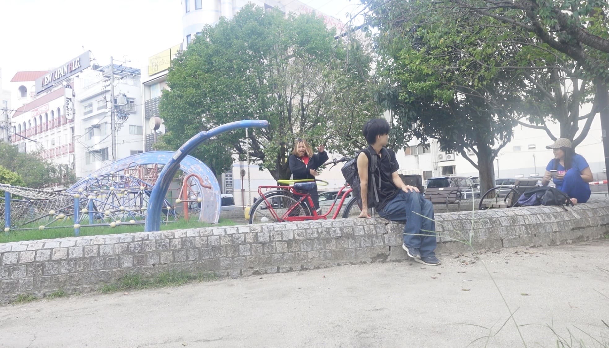 A man talking with two Filipino women in Ikeda Park