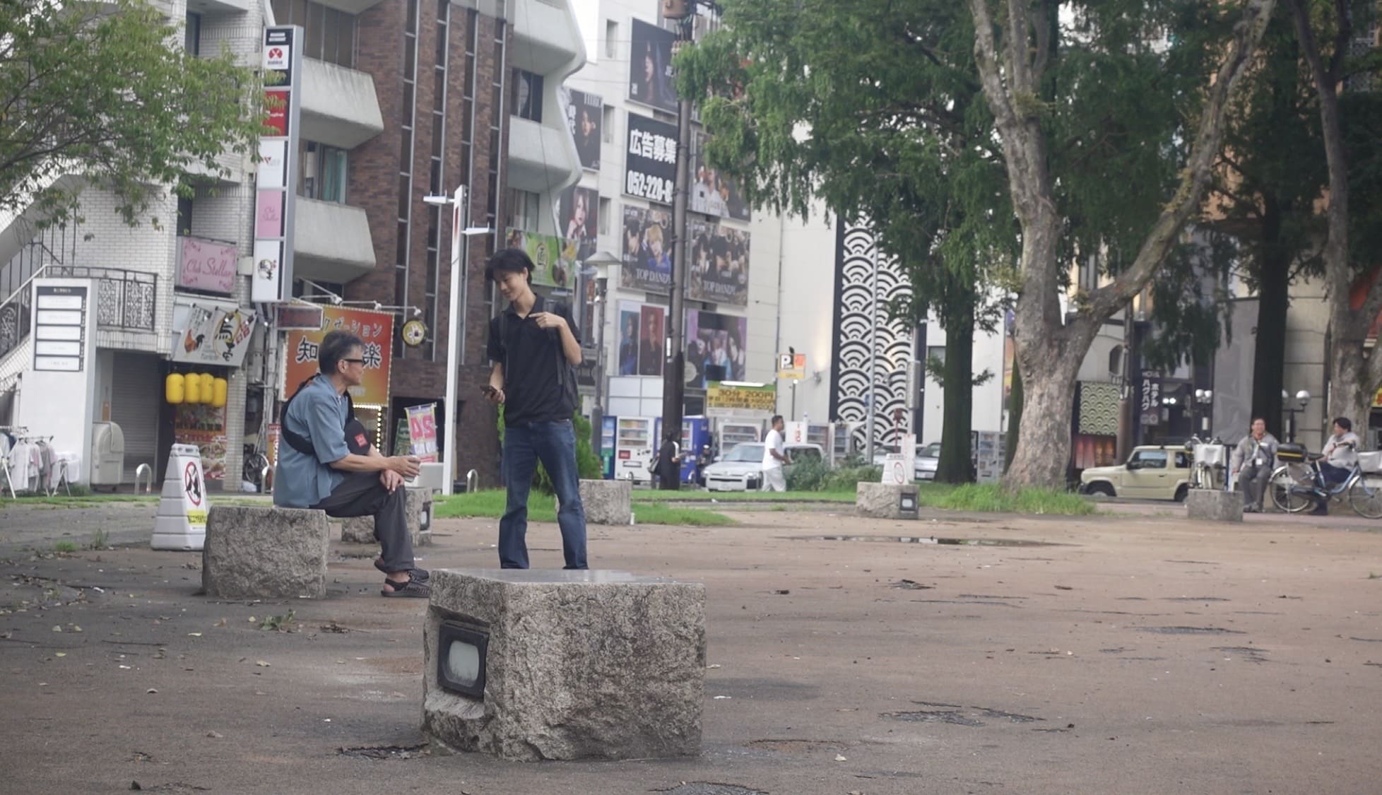 A man talking to a Japanese man at Ikeda Park at night