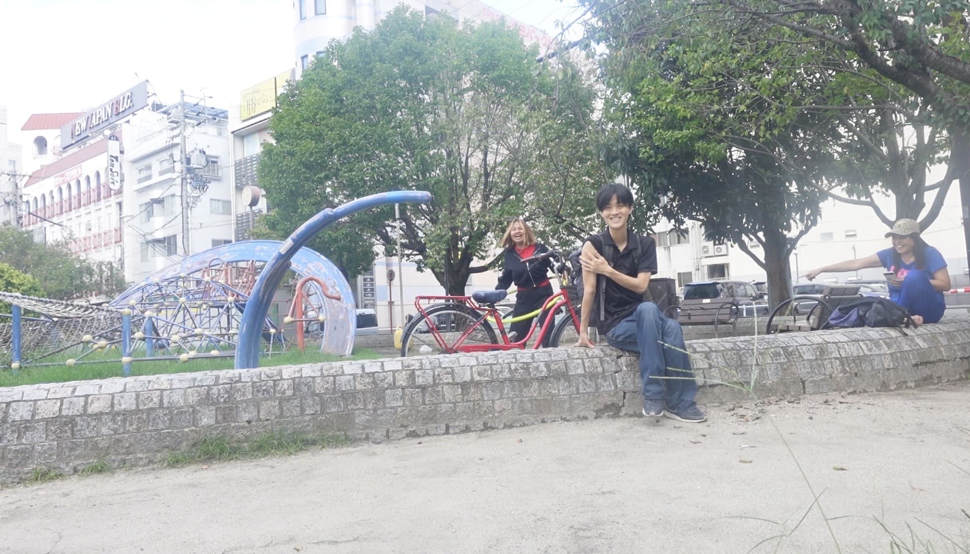 A man talking and laughing with two Filipino women at Ikeda Park