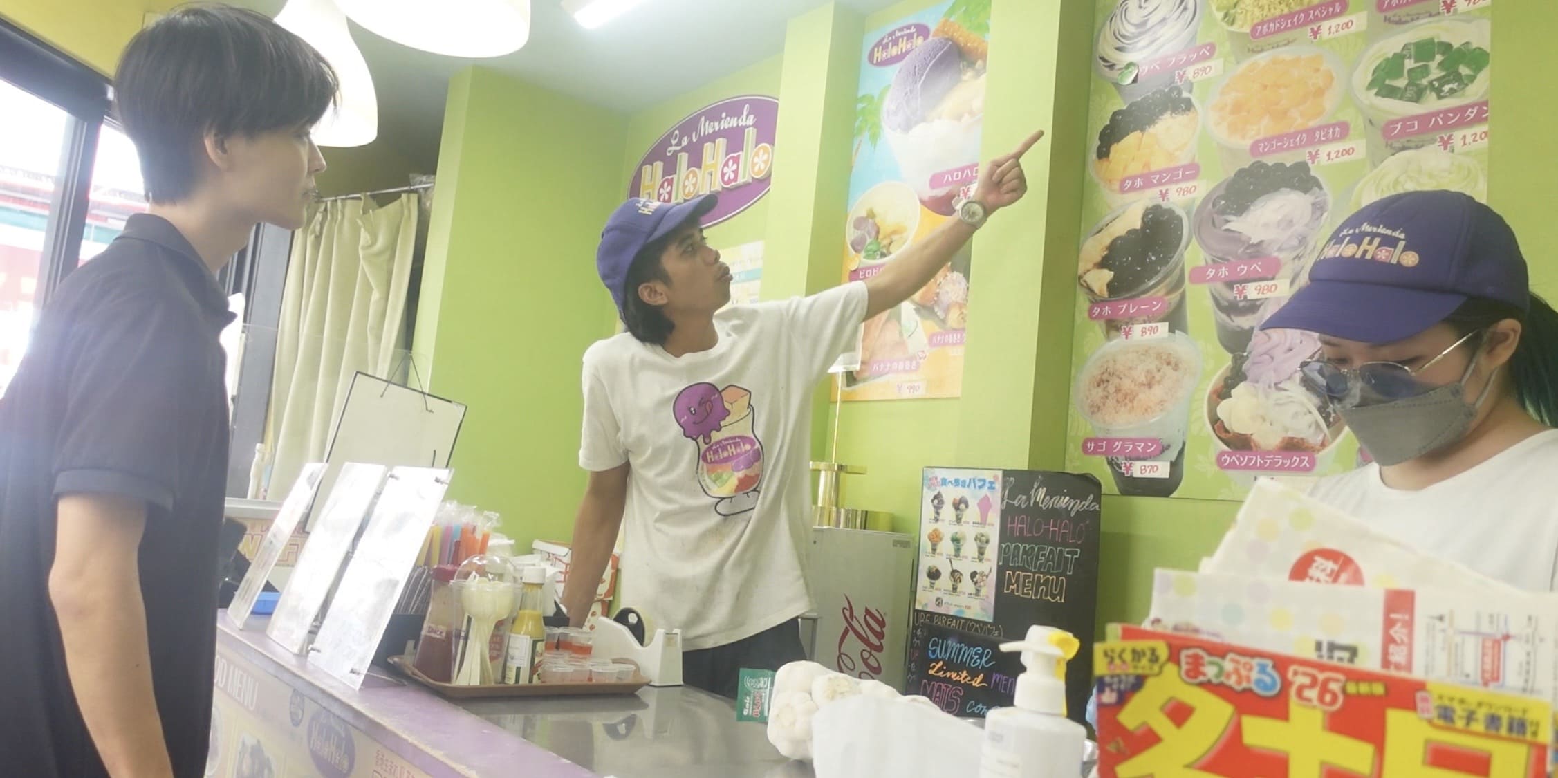 Filipino male staff member pointing at a taho menu