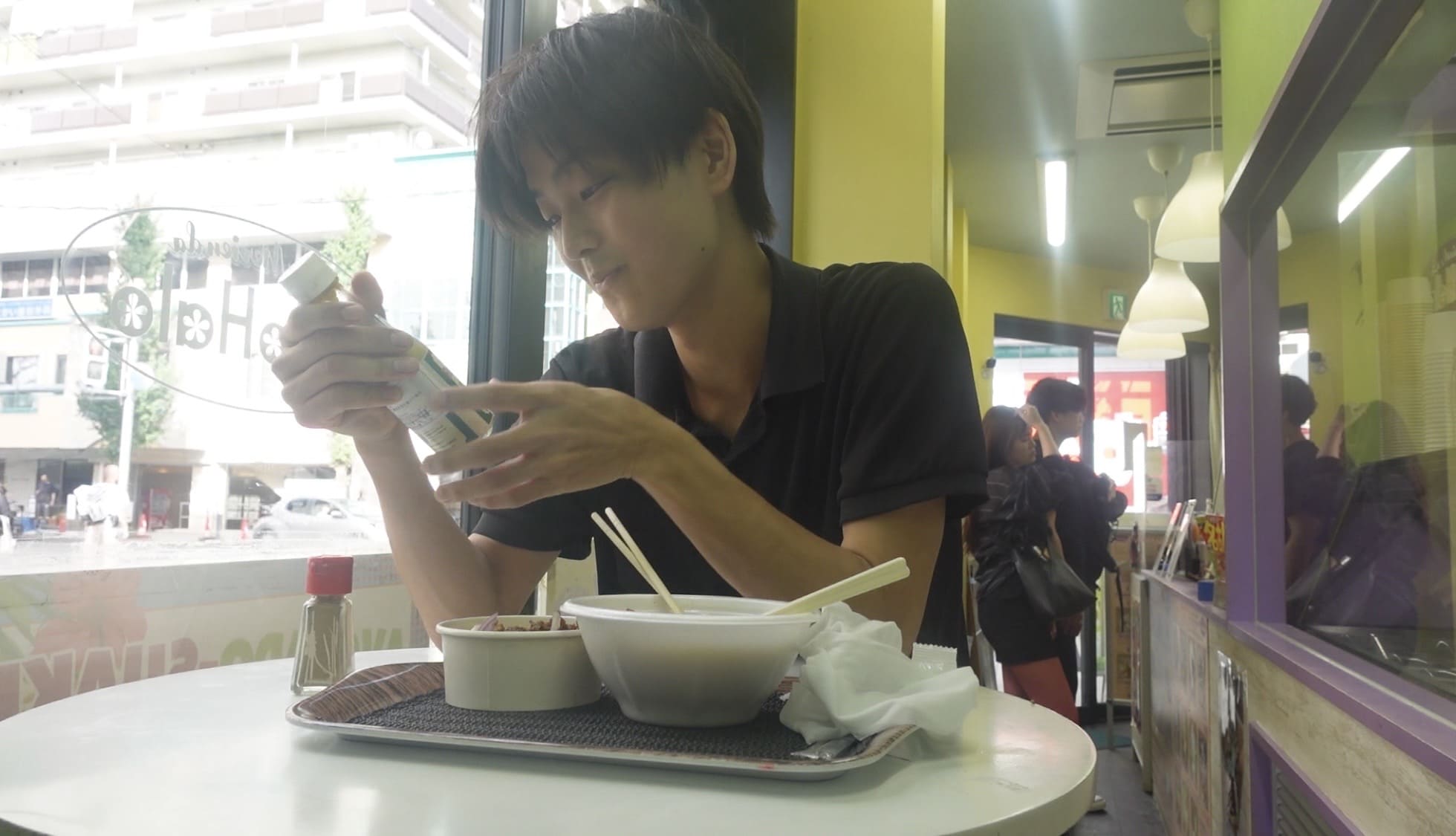Man eating lugaw at a Filipino restauran