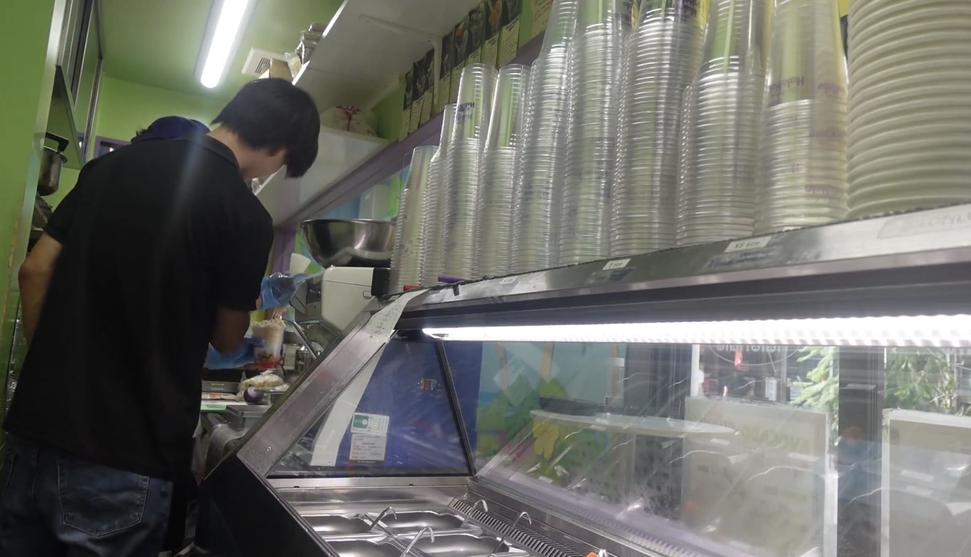 Man talking with a staff member inside a halo-halo shop