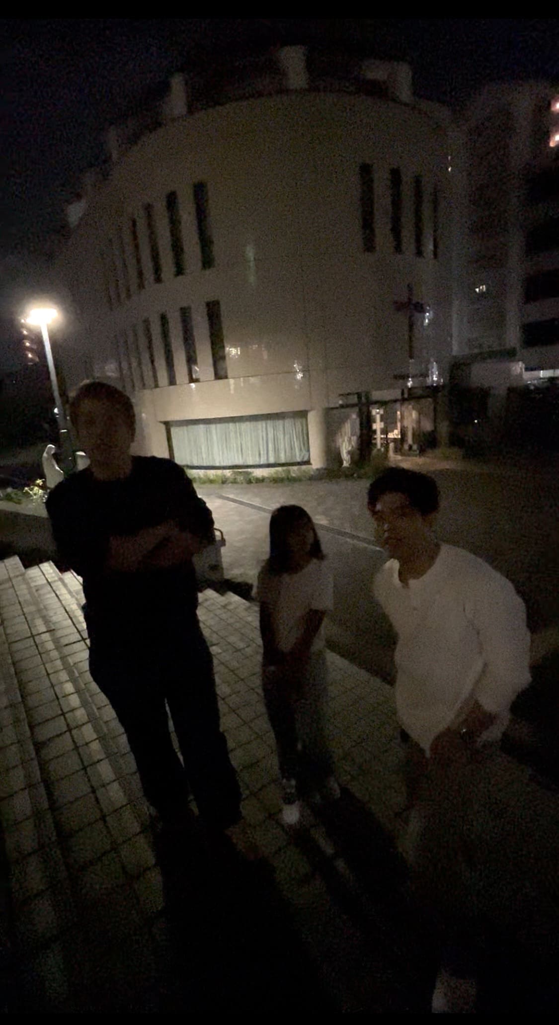 Two Filipino men and a Filipino woman outside Nunoike Church in Nagoya at night