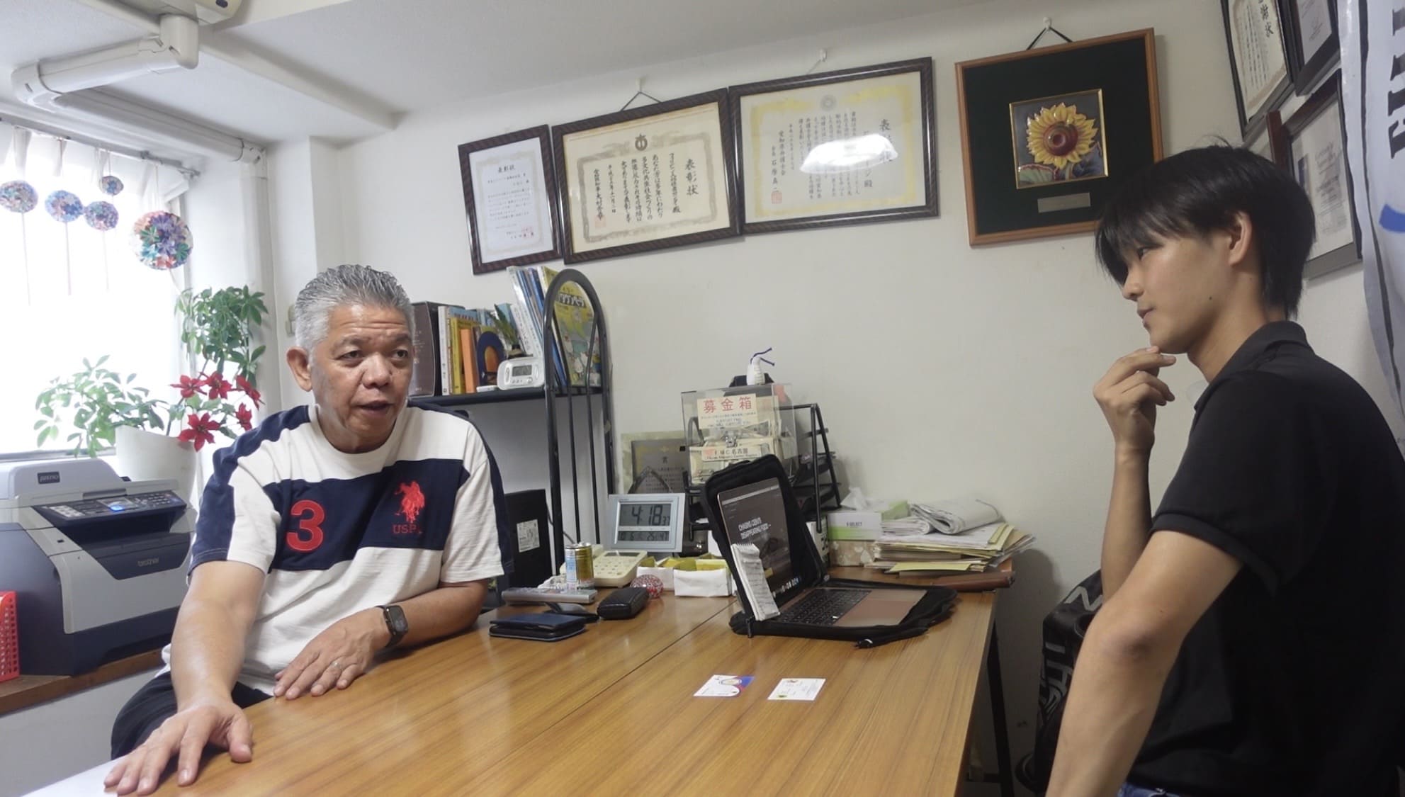 Two men having a serious conversation inside an office in Nagoya