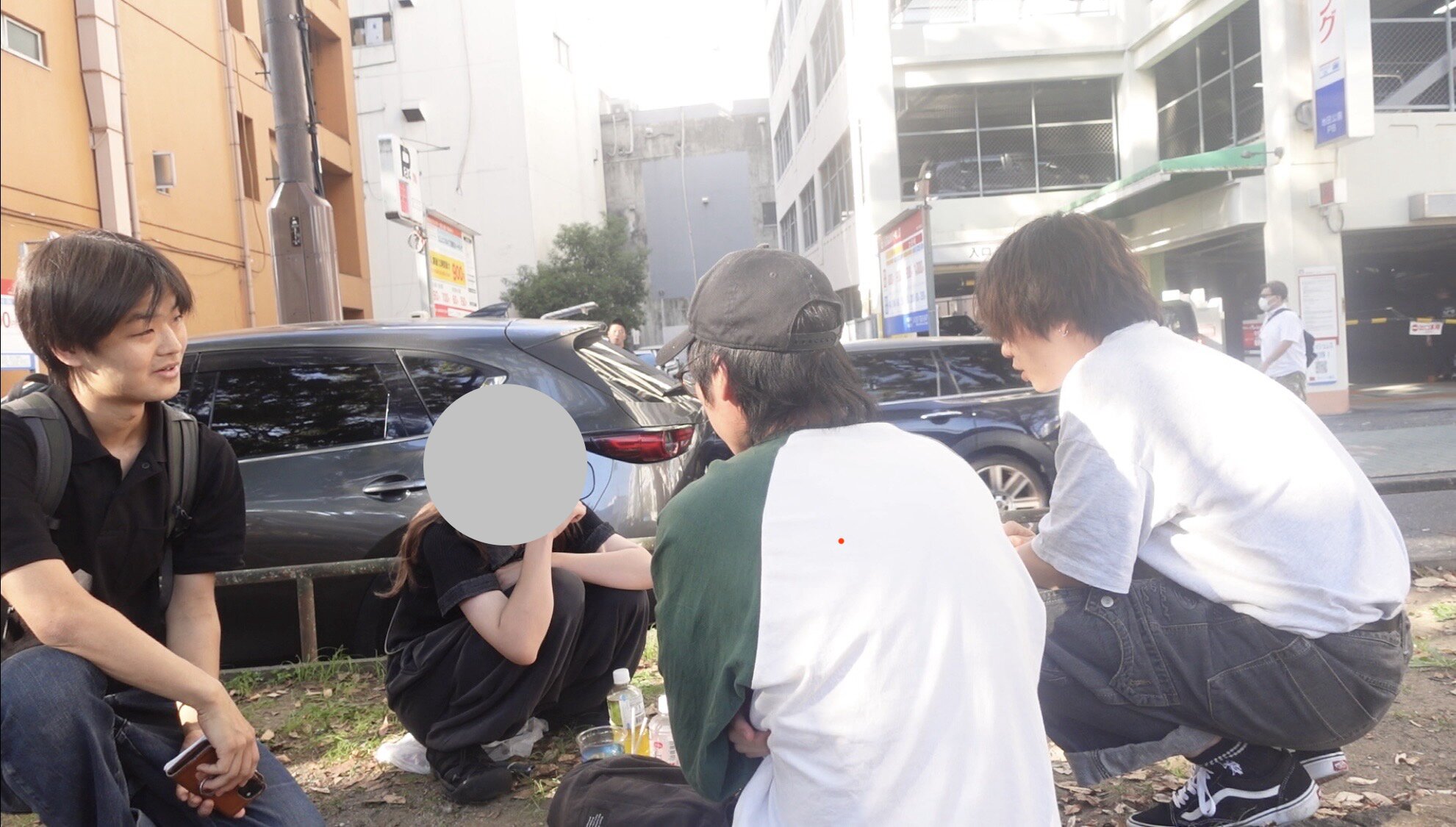 Three men and one woman talking together in a public park in Nagoya, Japan