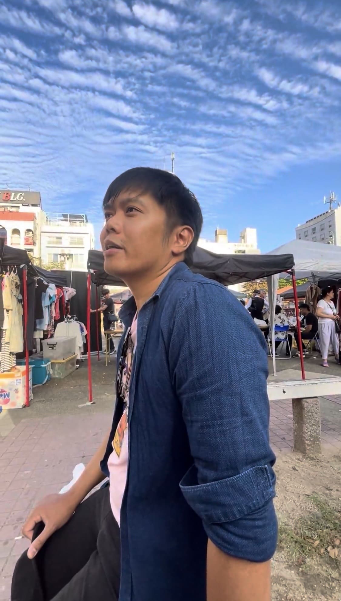 Filipino man sitting in a park and talking during an interview 