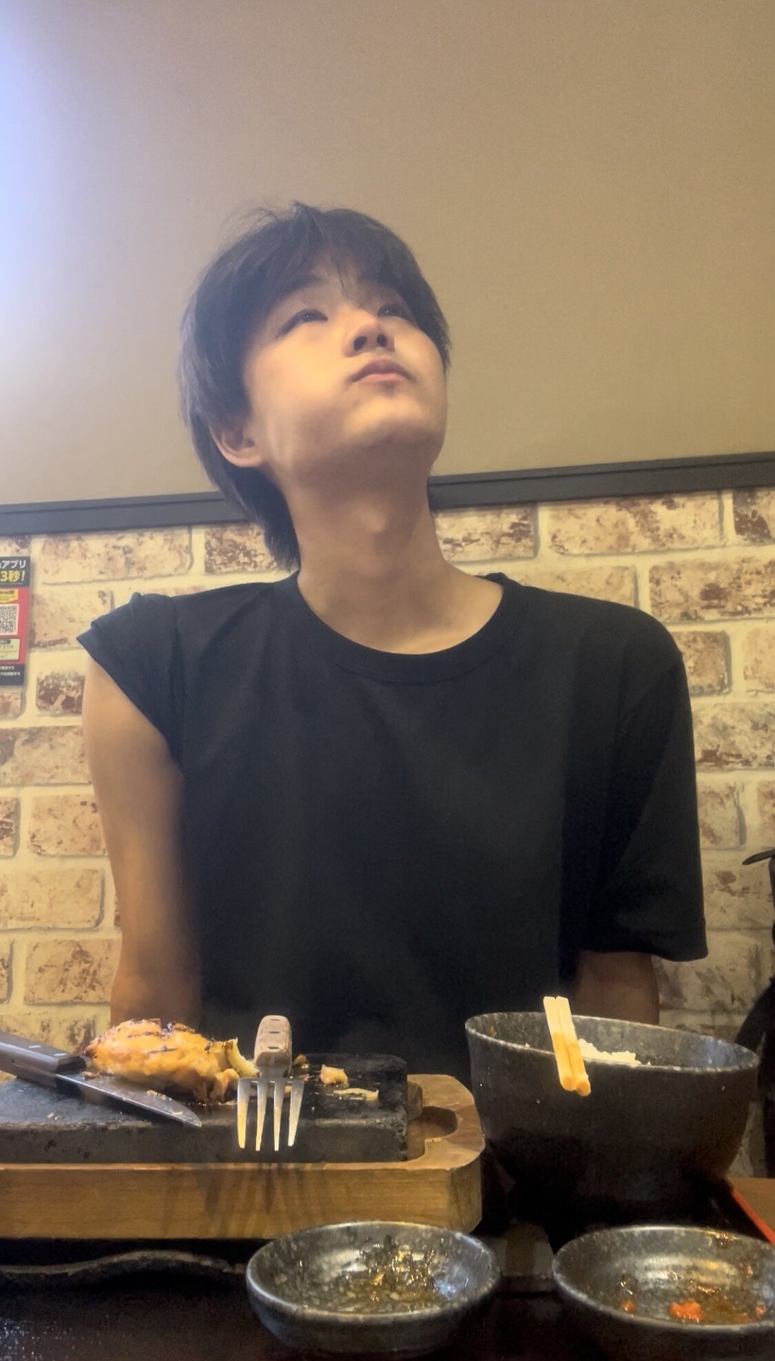 A man thinking while eating rice at a restaurant table