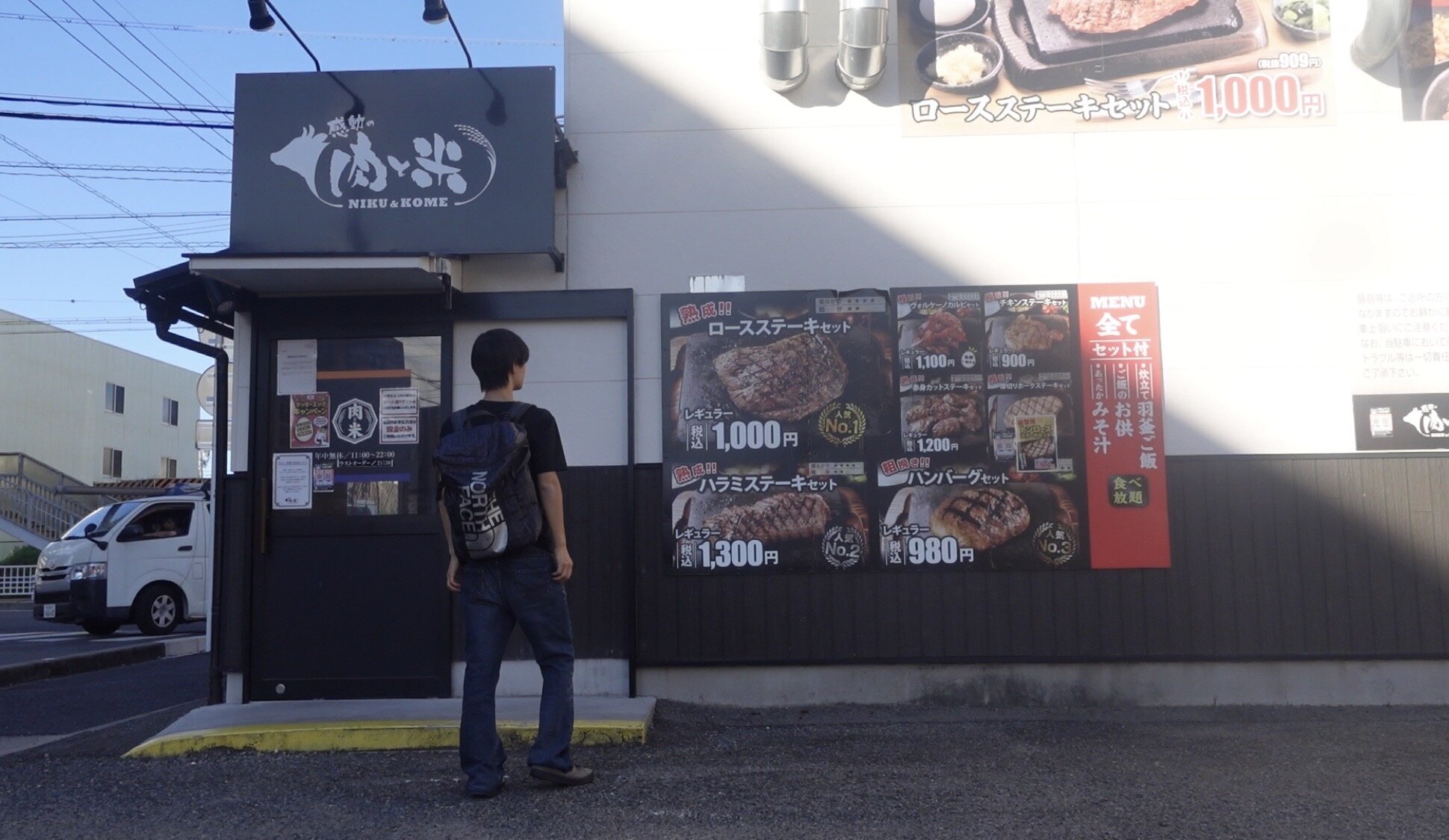 A man standing in front of a steakhouse